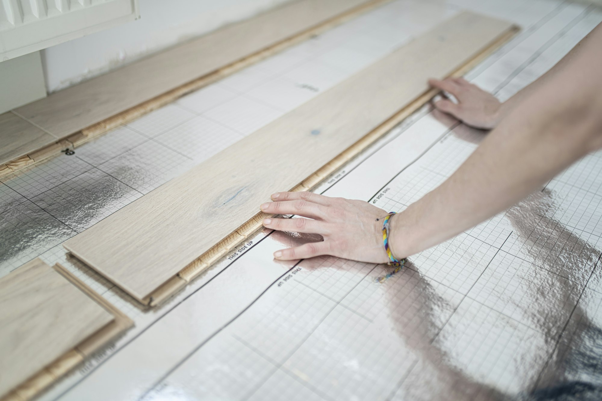 Woman laying footstep sound insulation, partial view