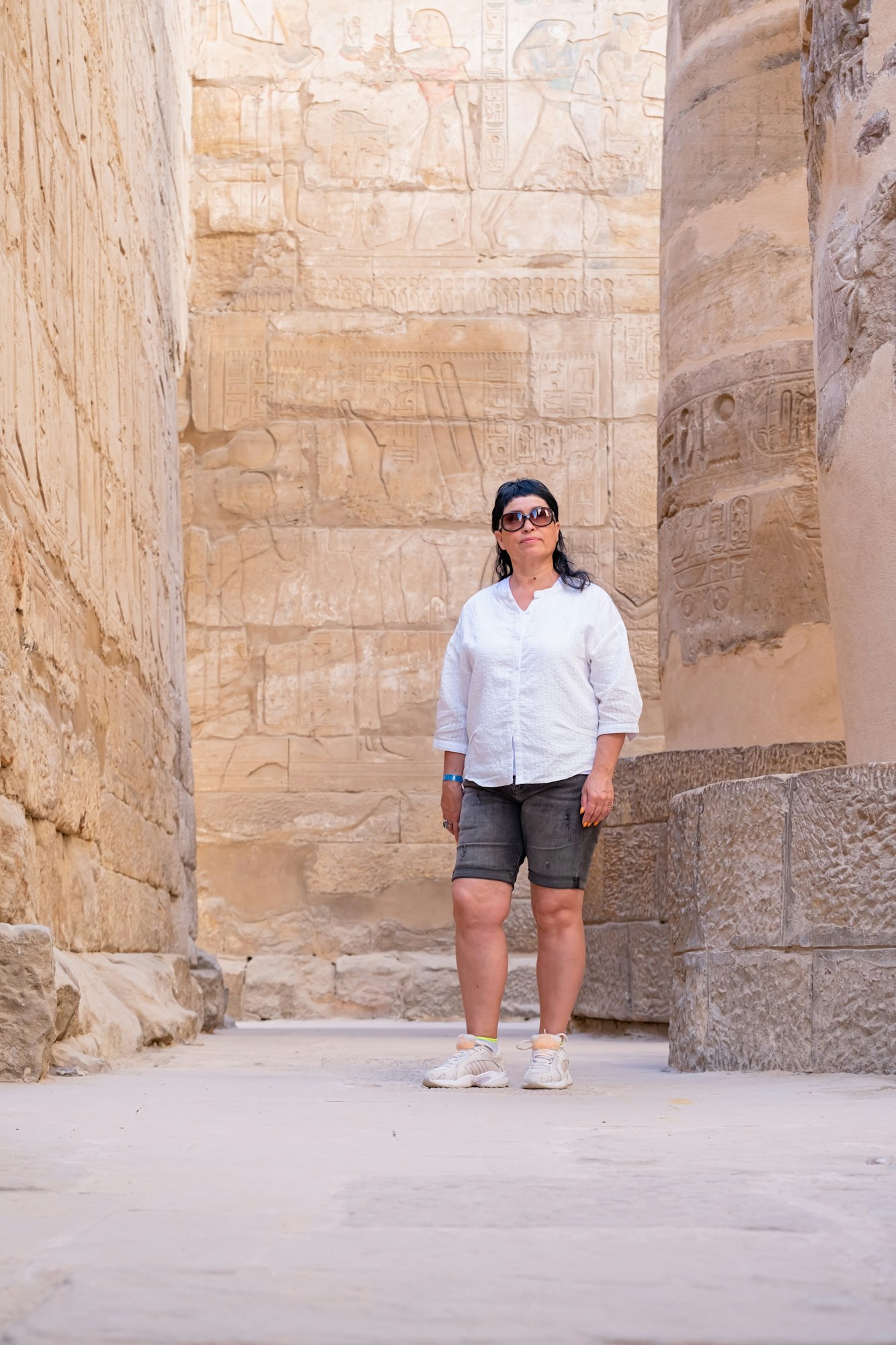 Woman traveler explores the ruins of the ancient Karnak temple in the city of Luxor in Egypt.
